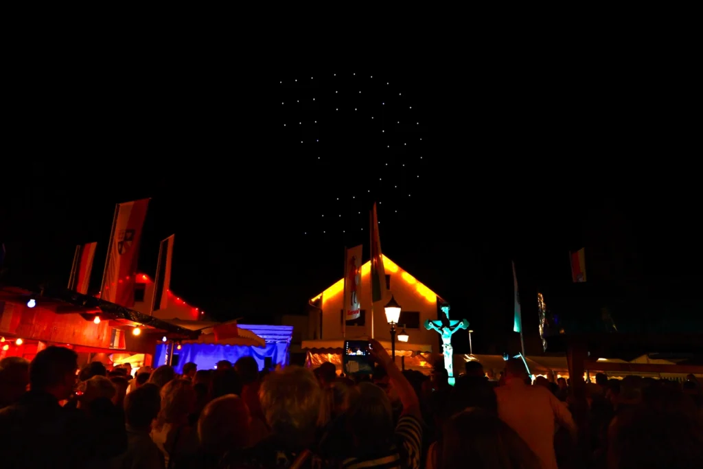 DROMOTION-Logo aus leuchtenden Show-Drohnen am Nachthimmel über dem Kartunger Straßenfest 2026